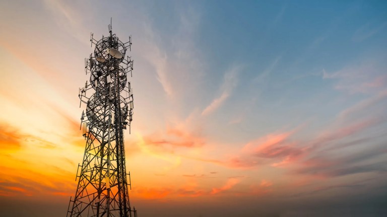 A cell tower with a sunset in the background.