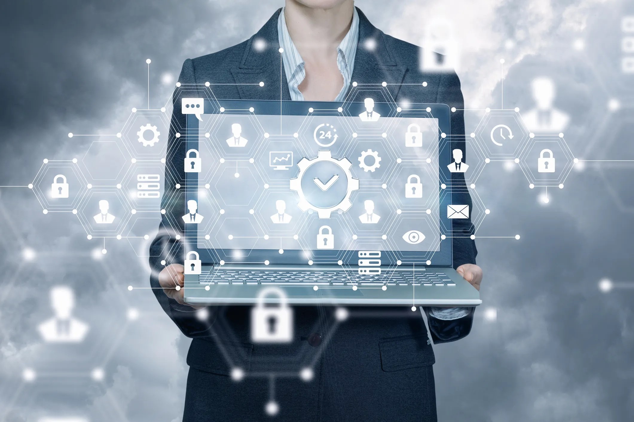 A business woman holding a laptop with icons on it.