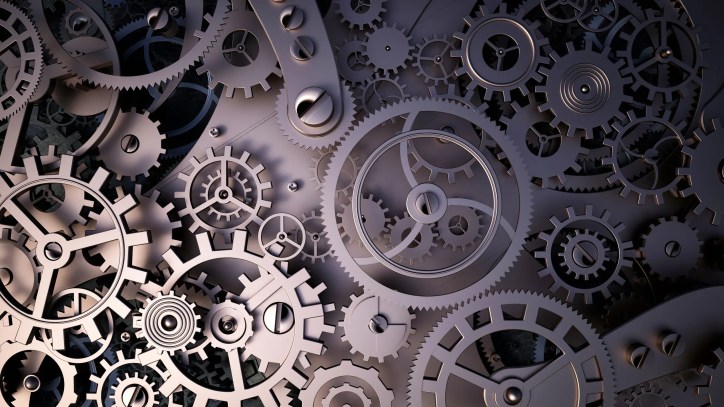 A close up of gears and cogs on a black background.