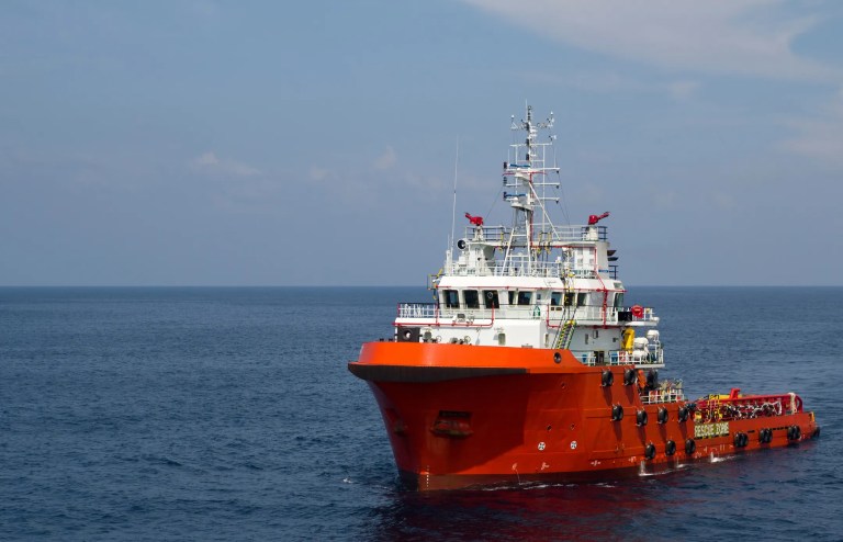 Red supply vessel moving through the seas.