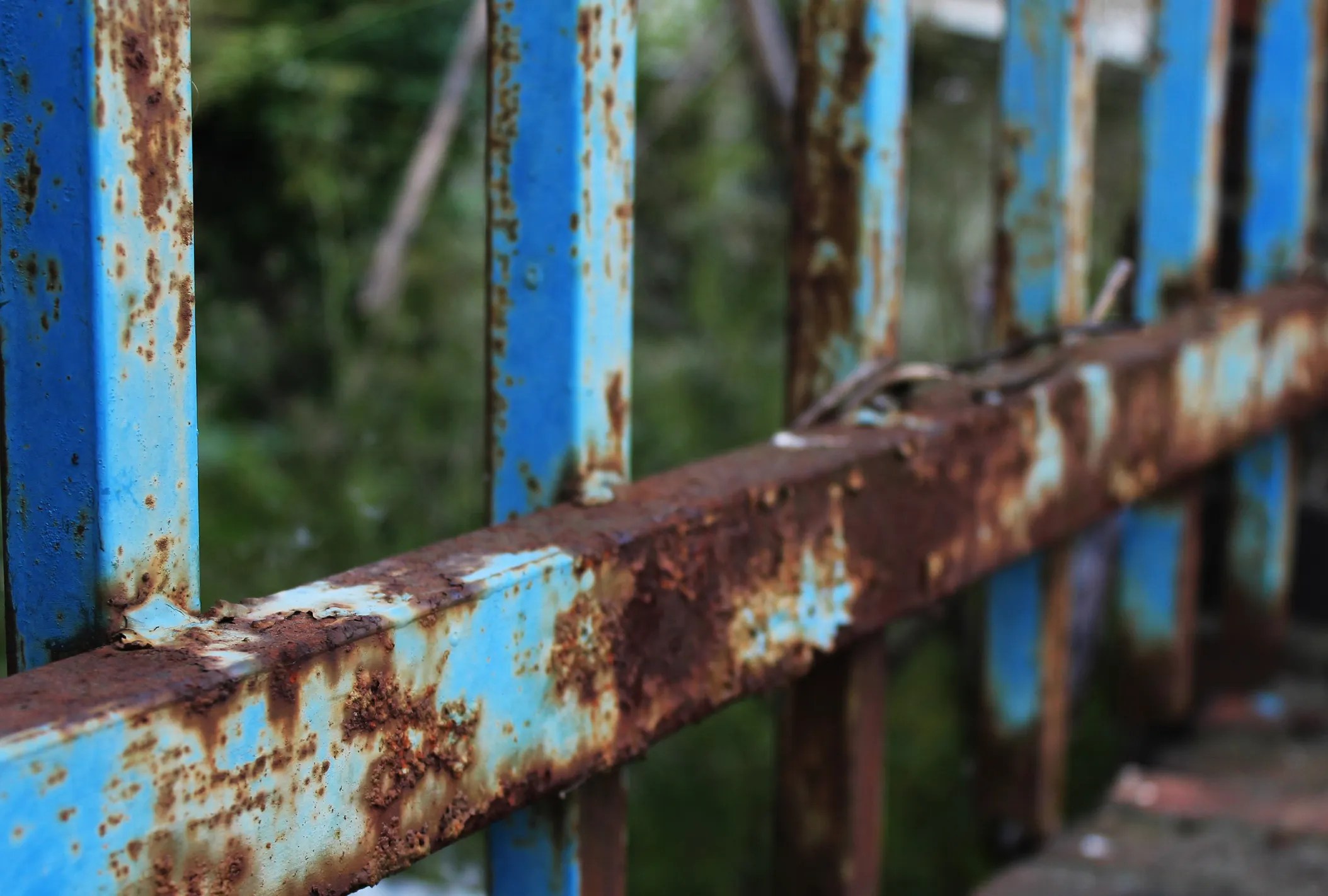 Corroded blue fence outside.