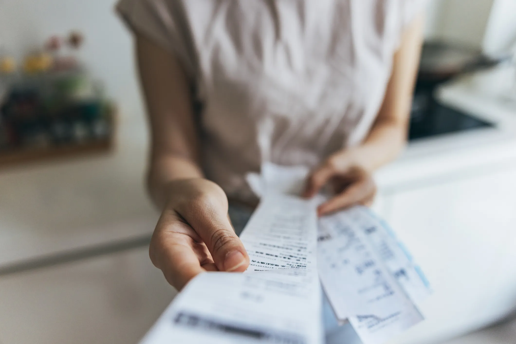 Hands holding receipts to analyze final balance.