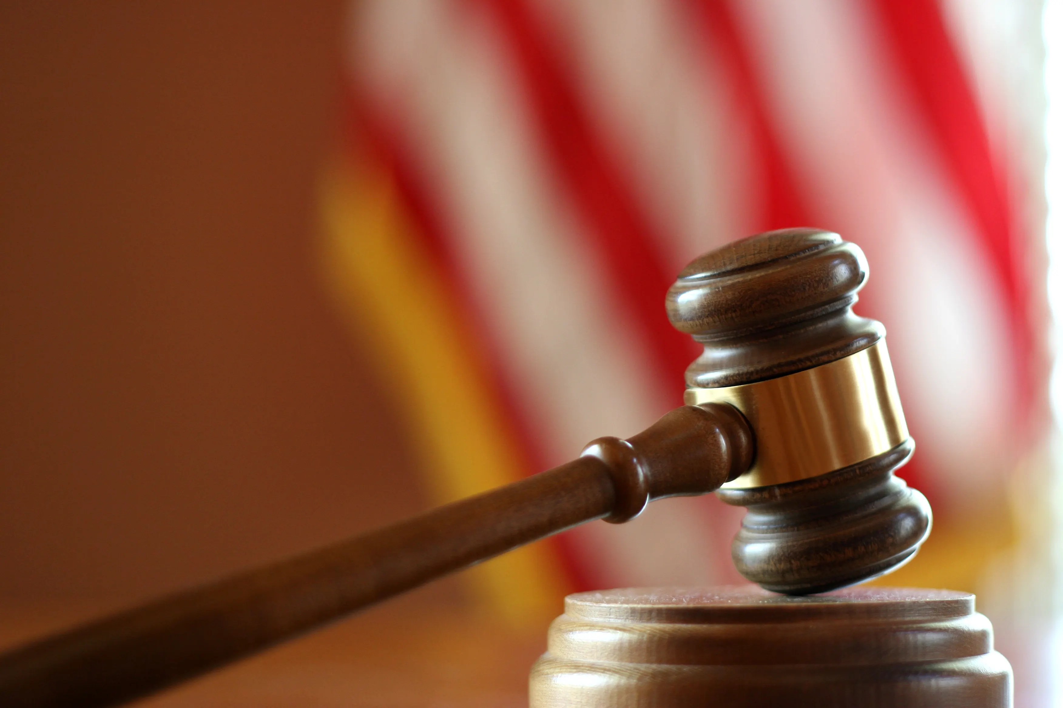 Court gavel striking in front of American flag.