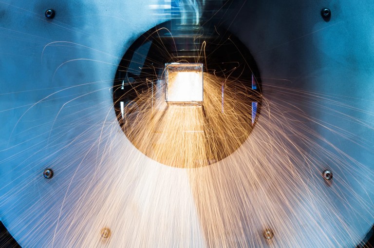 Laser welding with sparks flying on aerospace metal.