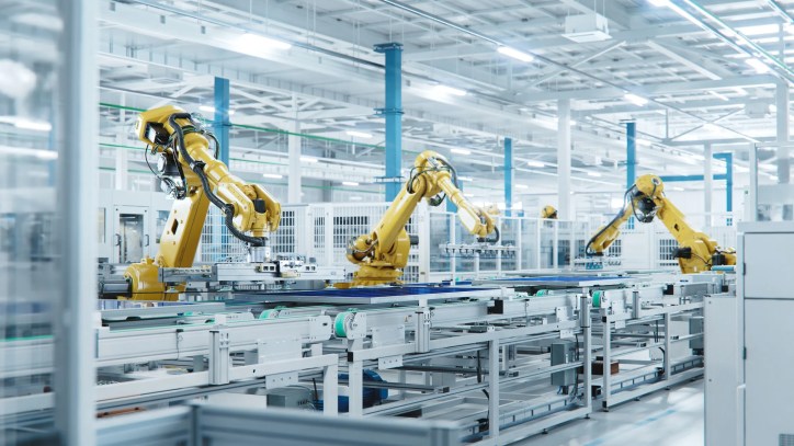 Three yellow arms working in automation at factory.
