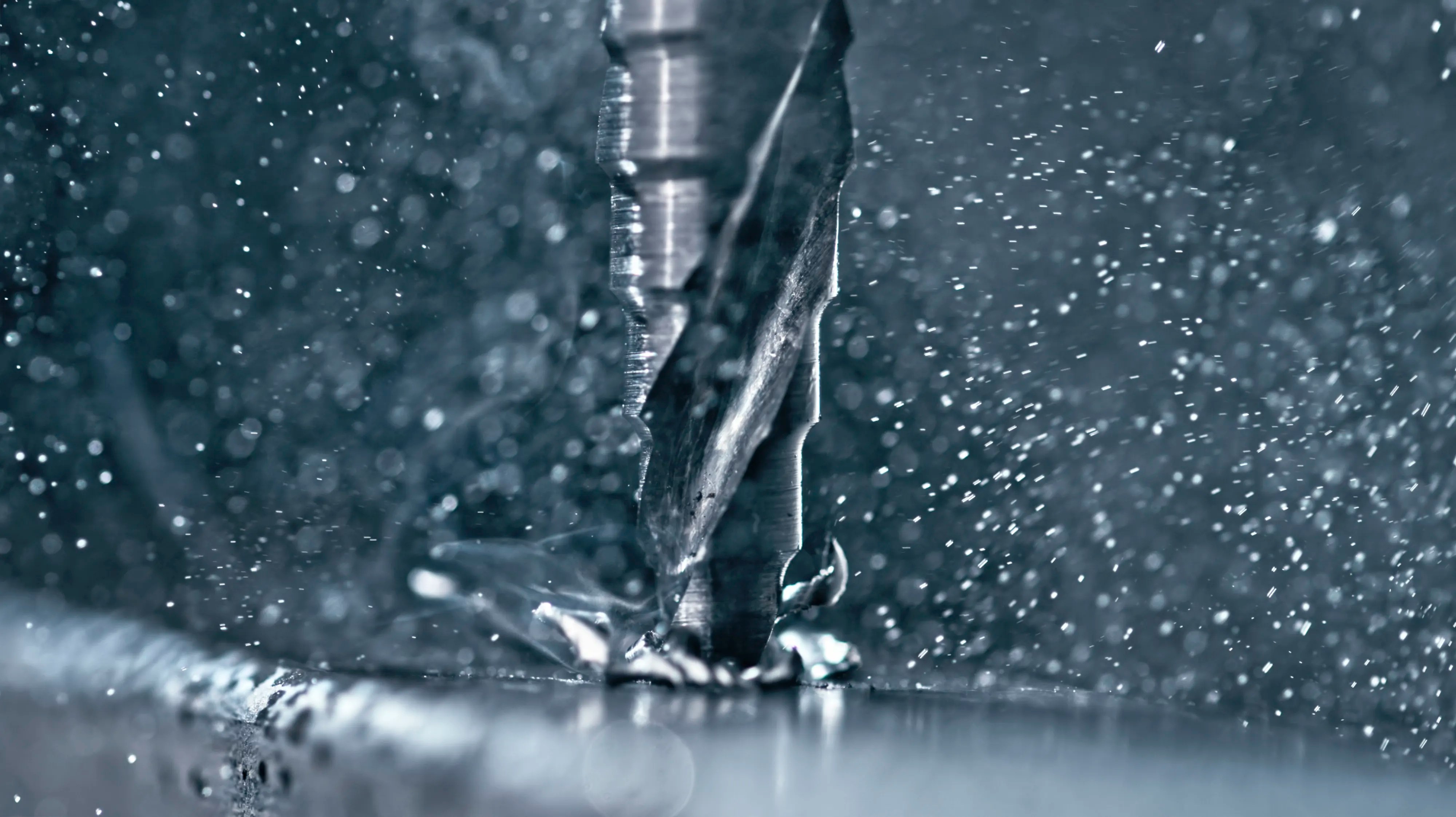 Drill bit cutting into metal close up.