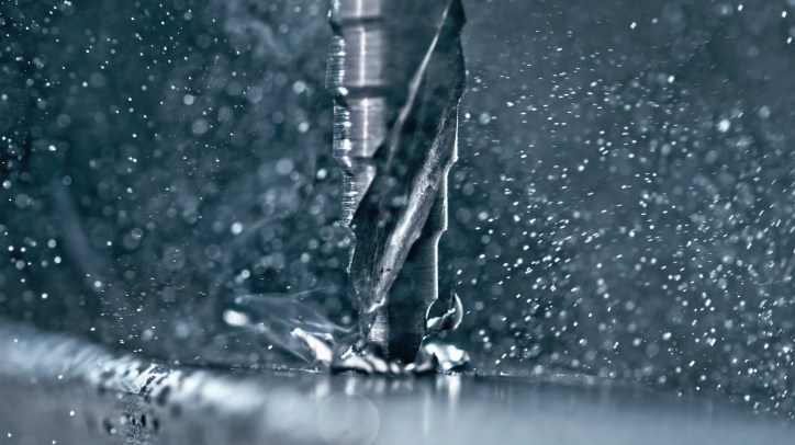 Drill bit cutting into metal close up.