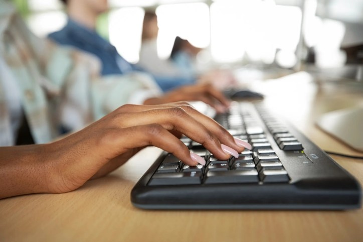 Typing on computer in ergonomic ANS/HFES 100 engineered style.