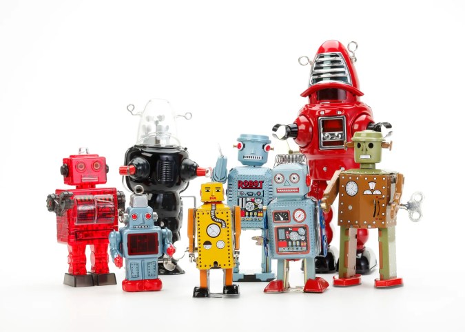 Retro robot toys on white background to be taught.