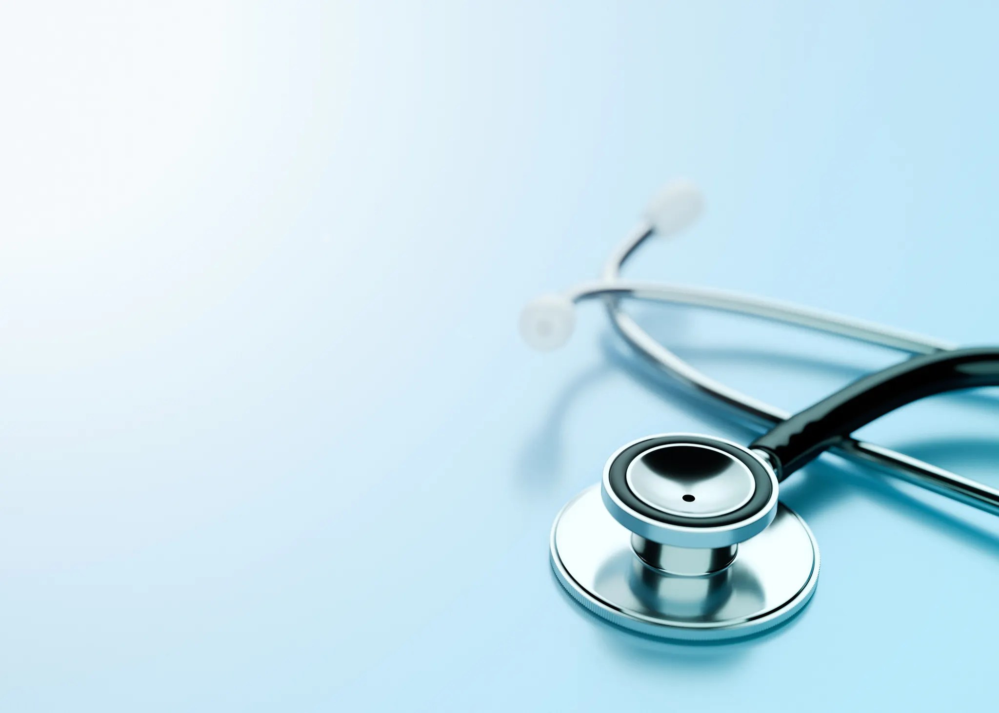 Stethoscope laying on light blue surface with ISO 9000 requirements.