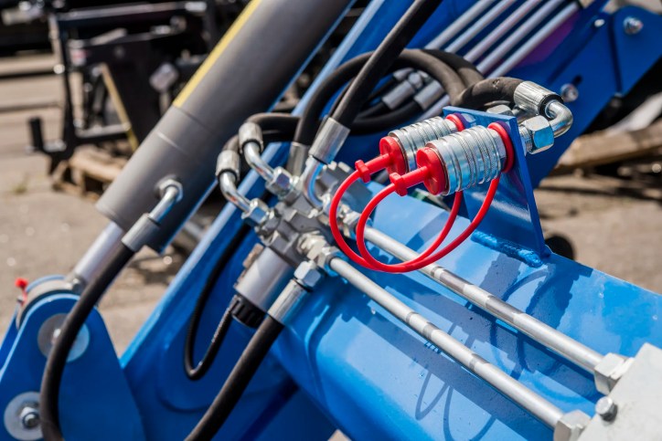 Close up of hoses using pneumatic power to operate blue tractor.