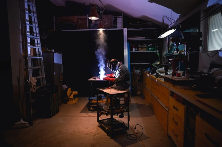 Welder working in dark shop