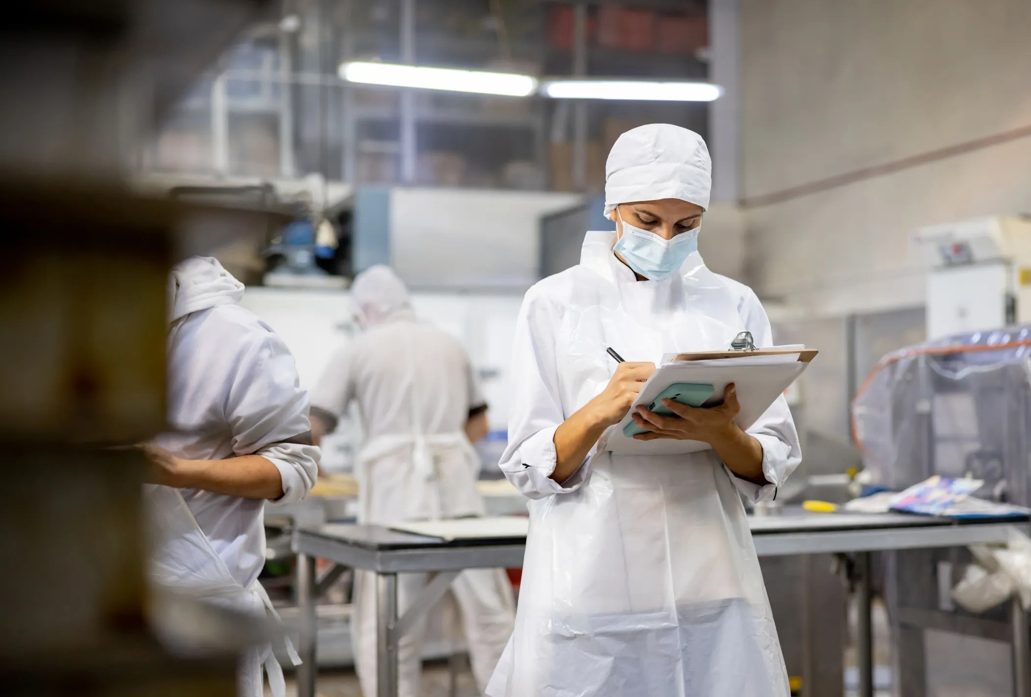 Food safety worker looking at clipboard to analyze lab results.