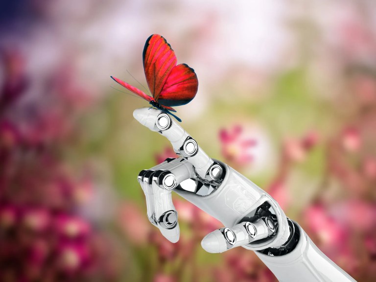 Red butterfly landing on extending robot hand.
