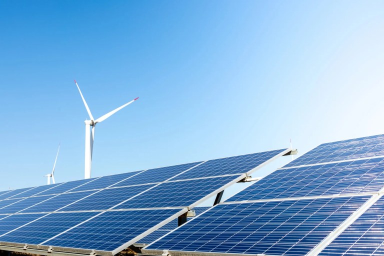 Wind turbine behind two solar panels
