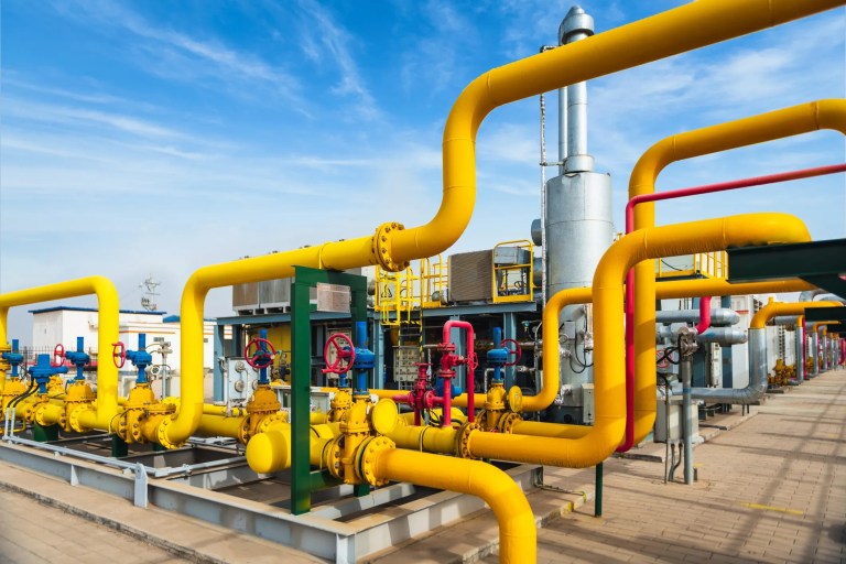 Yellow petrochemical pipes winding with red valves outside