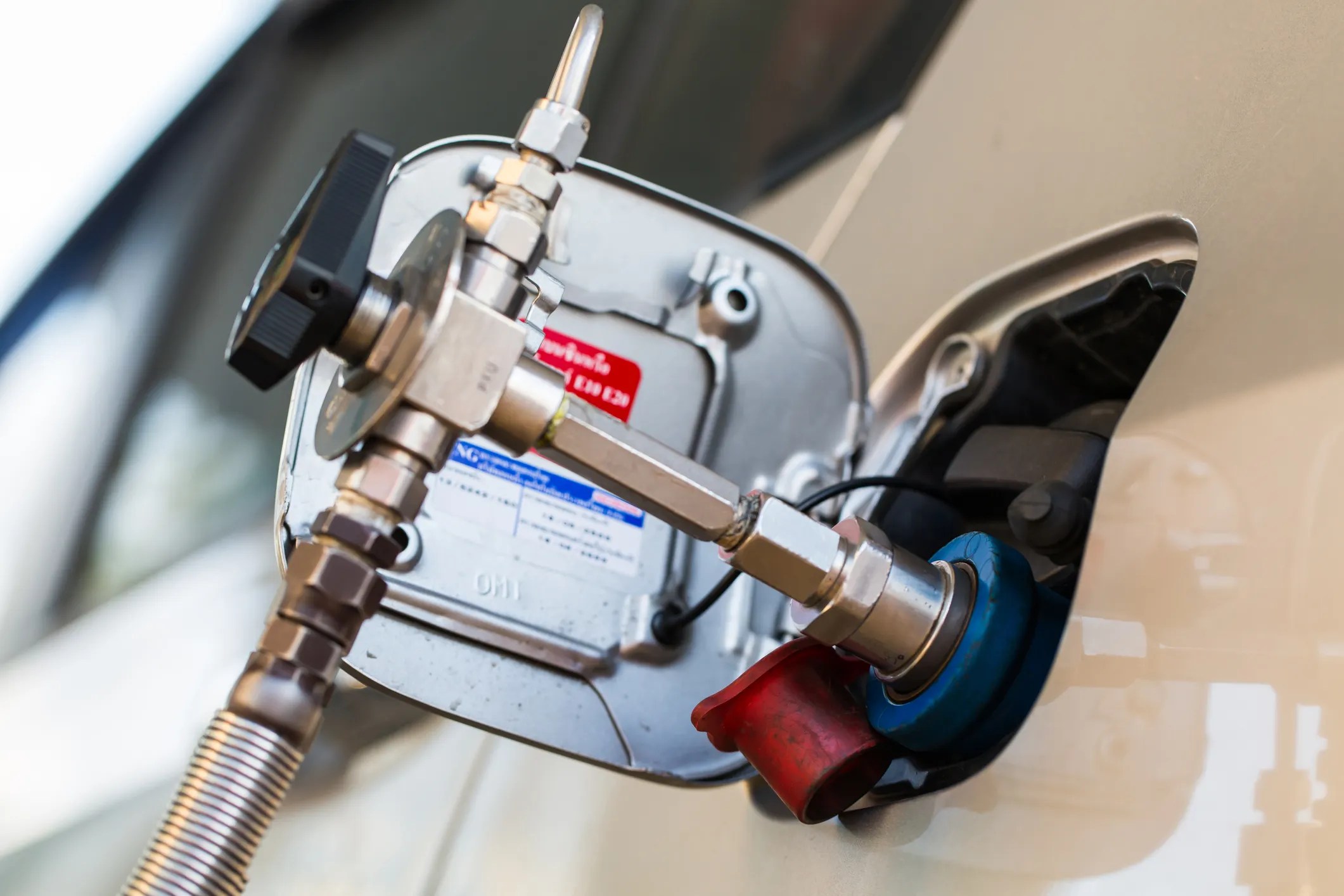 Compressed natural gas (CNG) vehicle being refueled through inserted nozzle
