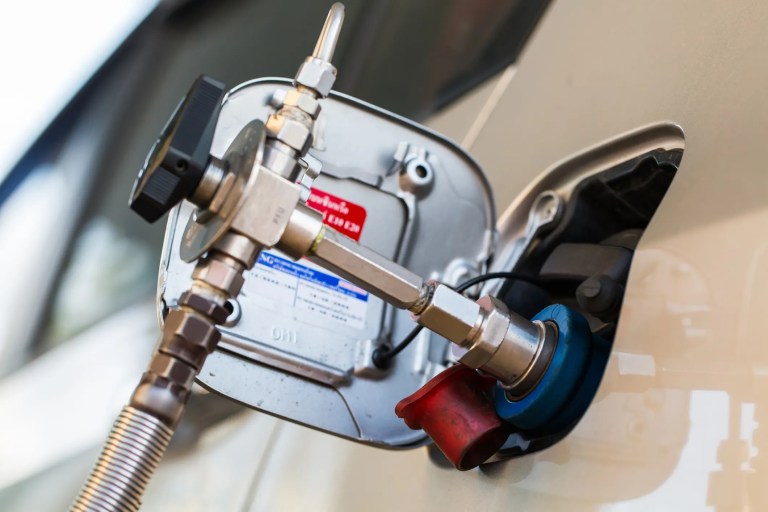 Compressed natural gas (CNG) vehicle being refueled through inserted nozzle