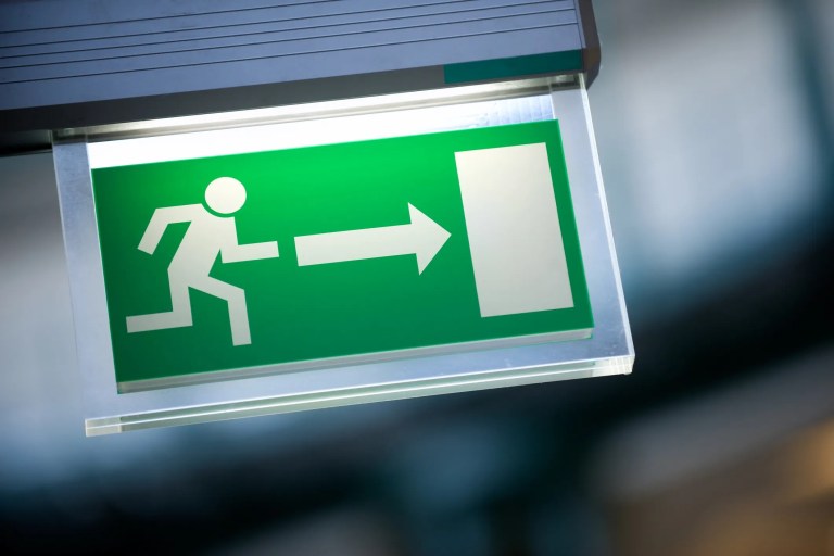 Green running man exit sign standard closeup