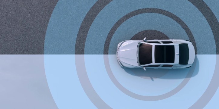 Self driving car moving on road with blue circles detecting nearby traffic