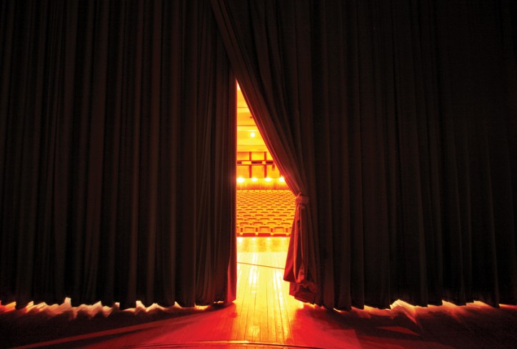 Curtain sliding open on stage, placing the star in the limelight.