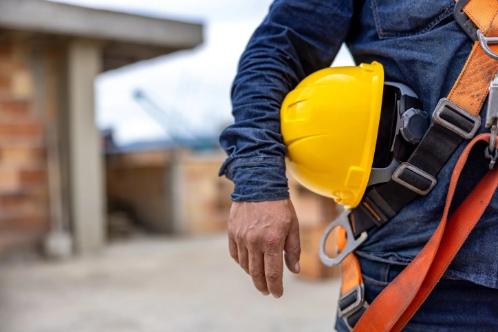 Man holding yellow hardhat in fear of reading OSHA top 10 violations