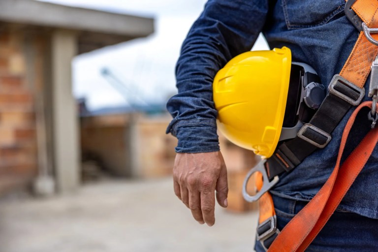 Man holding yellow hardhat in fear of reading OSHA top 10 violations