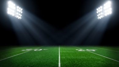 A verdant football field illuminating via IES RP-6-15 sports and recreational area lighting.