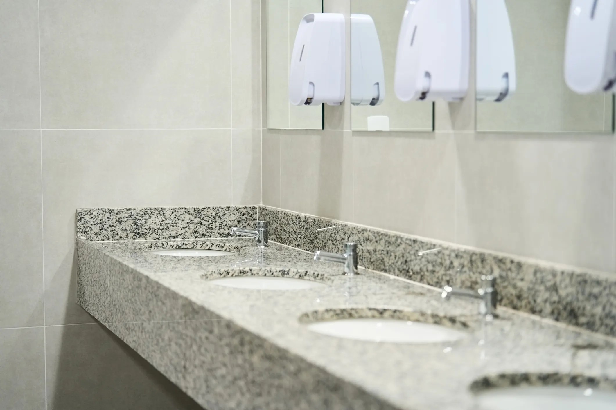Sinks lined up on granite in ANSI/PSAI Z4.1-2016 workplace bathroom