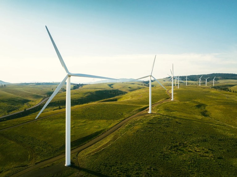 Sustainable wind farm turbines above green plains