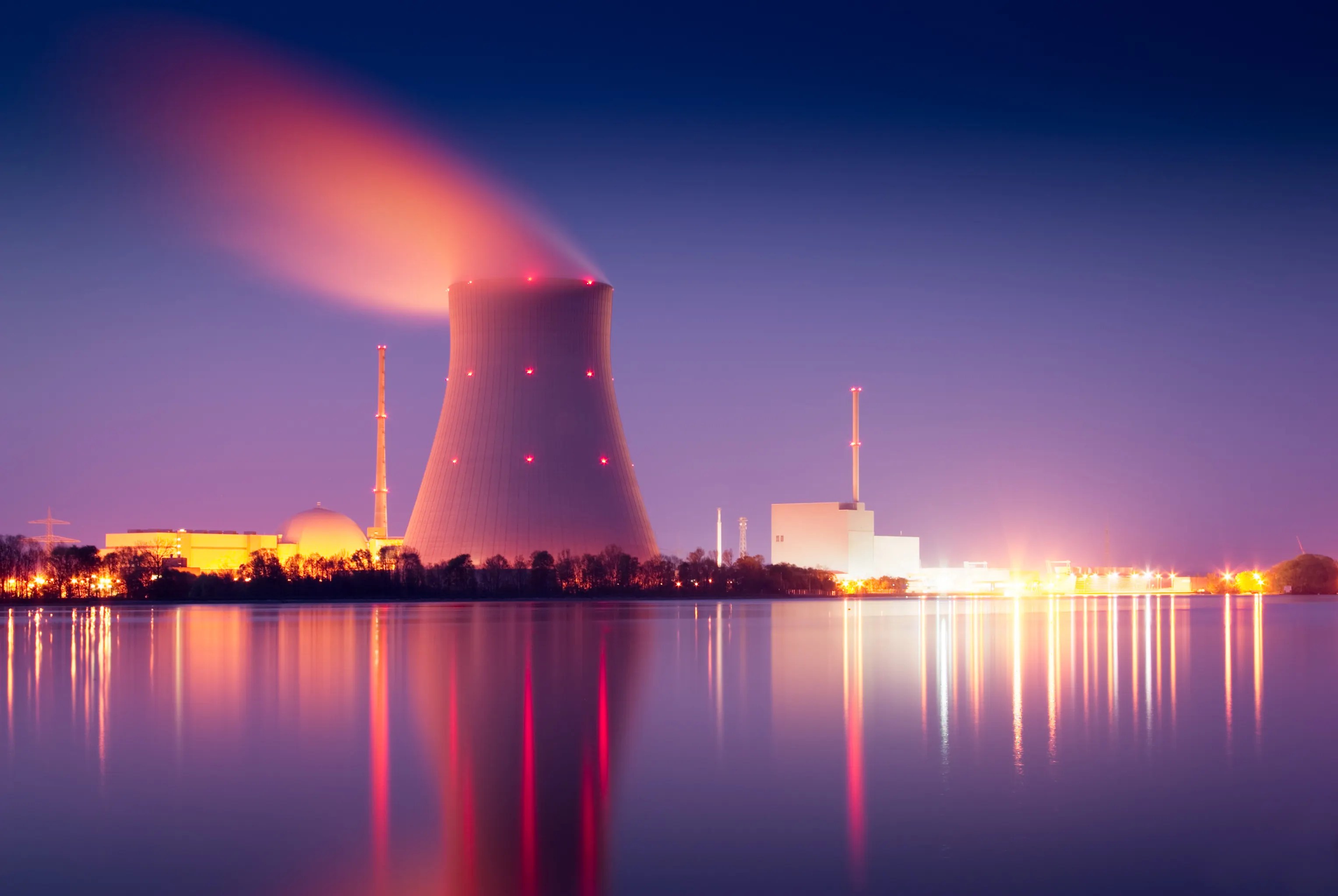 Single nuclear power plant cooling tower glowing red for seismic activity