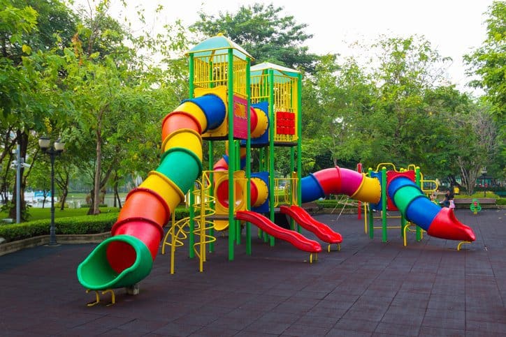 Colorful children's public playground kept safe with ASTM F1487-21.