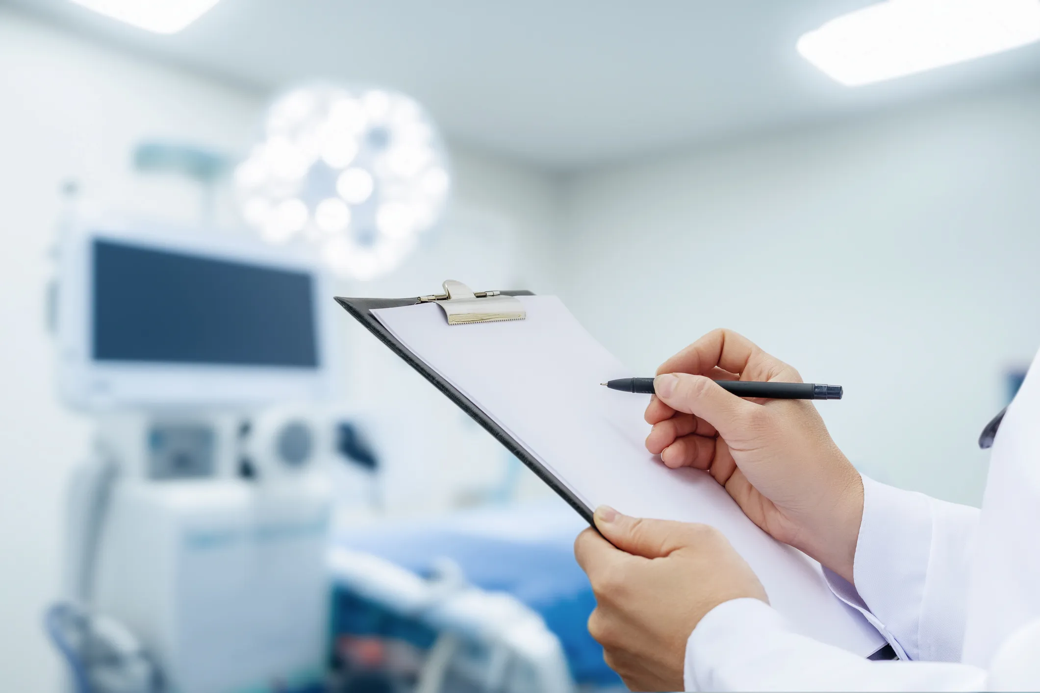 Checking the boxes on a clipboard to evaluate, via ANSI/IESNA RP-29-20, the effects illuminating health care spaces can have on health.