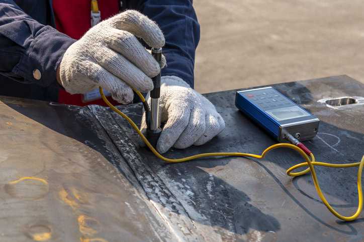 Brinell hardness testing being conducted on welded metal with ASTM E10 indenter.