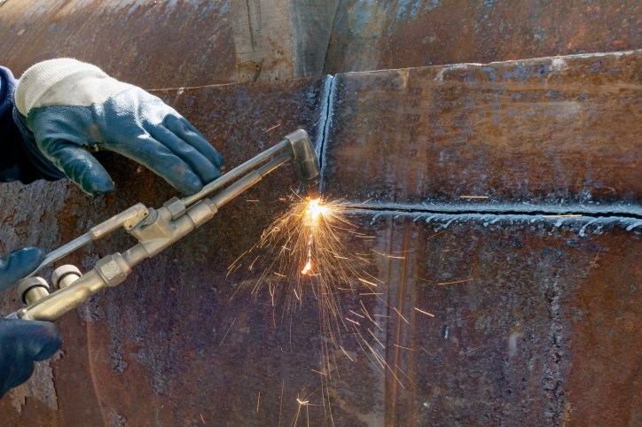 Oxy-Fuel Torch being used for CGA E-5-2017 cutting of rusty steel plate
