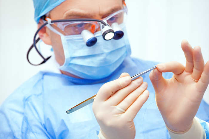 A dentist who has read ISO/TS 22911 is suited up and prepared for evaluating dental implant systems on animals.