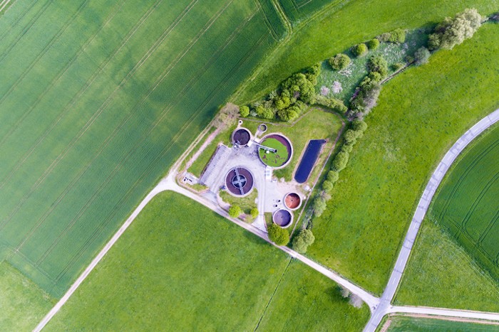 A vibrant green AWWA G520-2017 wastewater collection system used for operation and management.