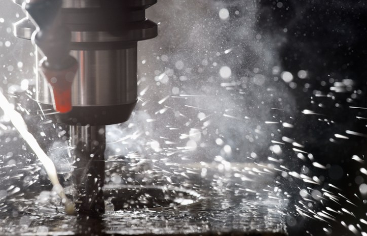 Factory drill with splashing flecks operating as one of the ISO Type ABC machinery according to ANSI B11