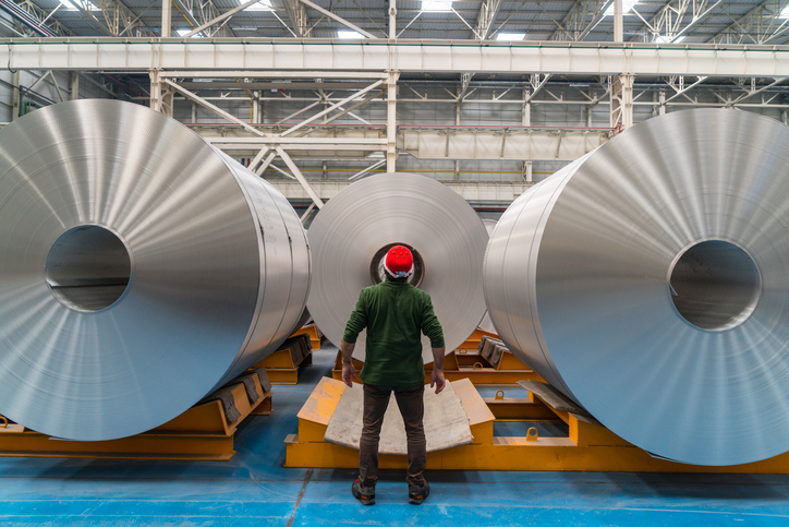 Man gazing in amazement at aluminum cylinders that follow aluminium standards.