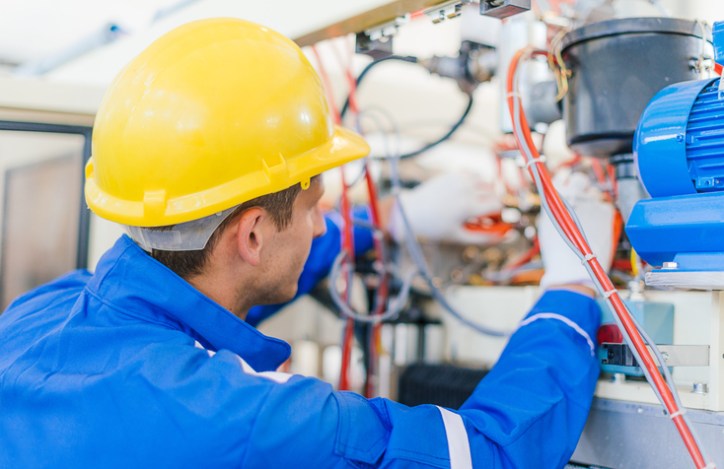 Worker repairing motor machinery and following NFPA 79-2018