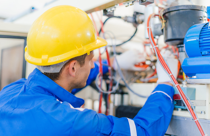 Worker repairing motor machinery and following NFPA 79-2018