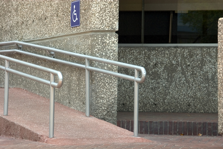 A ramp with metal railings shows the errata to ICC A117.1 2017 for accessible buildings corrections.