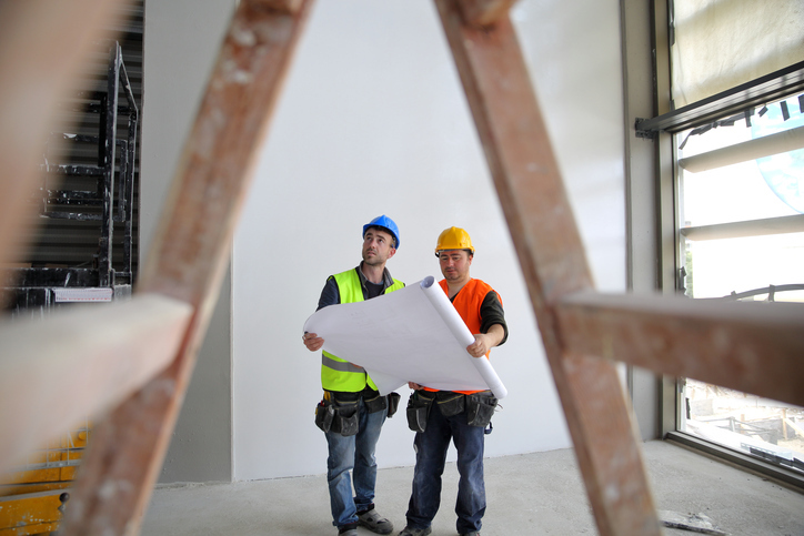 Duo at work making sure to note best ladder safety practices, since it's a big deal.