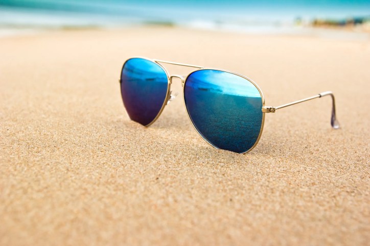 A cool pair of ANSI Z80.3:2025 sunglasses on the beach