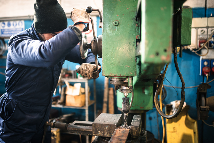 A worker using a power tool while following ISO 45001 2018