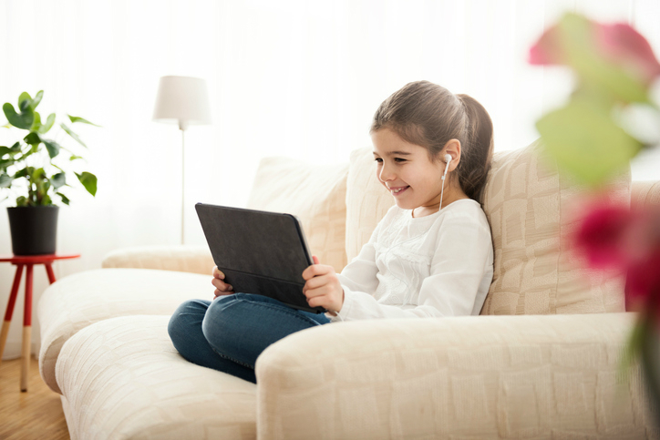 A child watching a video that follows ISO/IEC 14496 on a couch