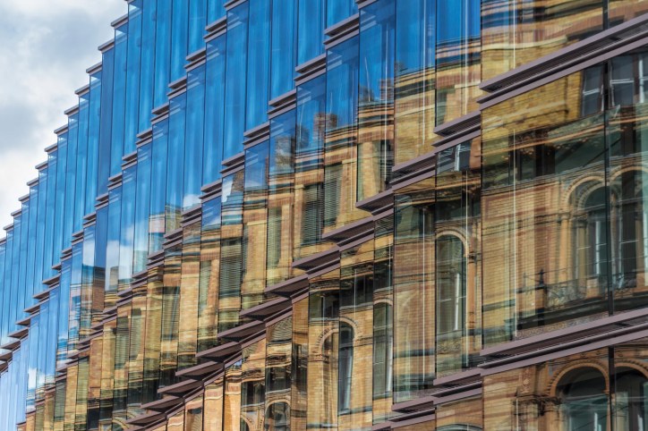 Side of a building with a lot of glass windows that follow the guidelines set in ANSI ASHRAE IES Standard 100