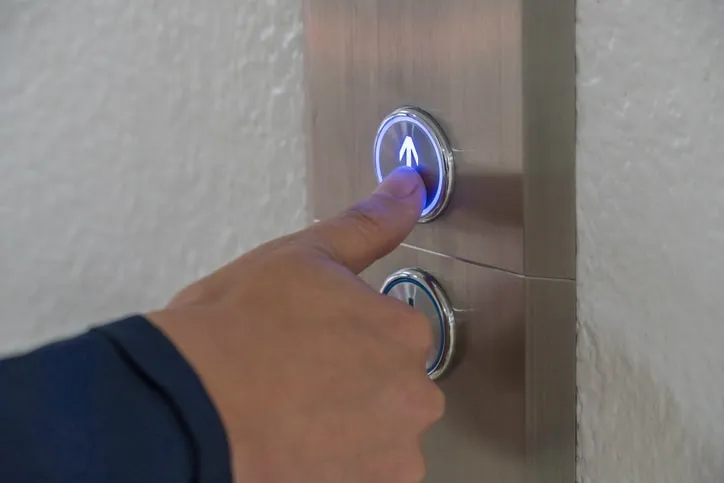 Pushing an elevator button up in accordance with ASME A17.1, or CSA B44, a binational standard.