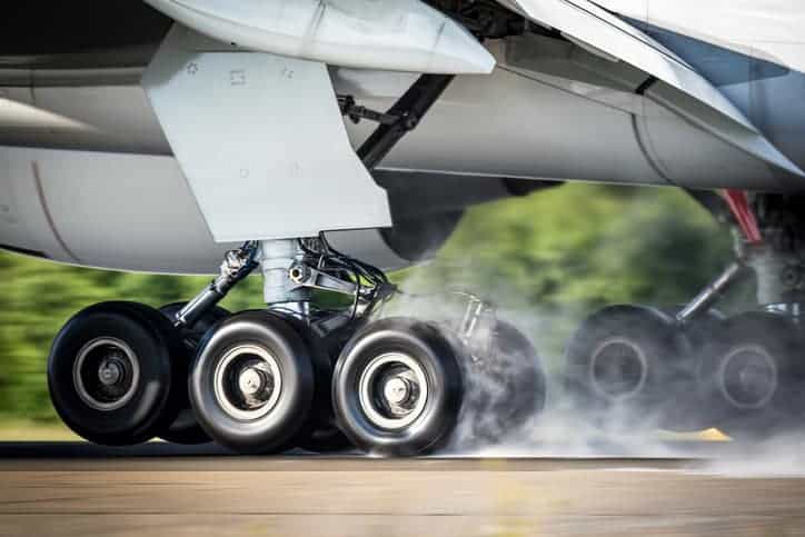 An aircraft landing to rubber burn and smoke, but it's secure thanks to SAE AMS 2430 shot peening.
