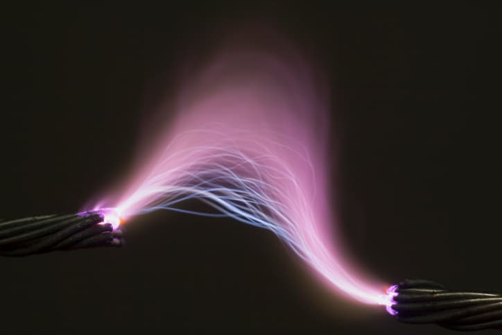 Bright purple electric arc illuminating the dark specified in ASTM F1506-22.